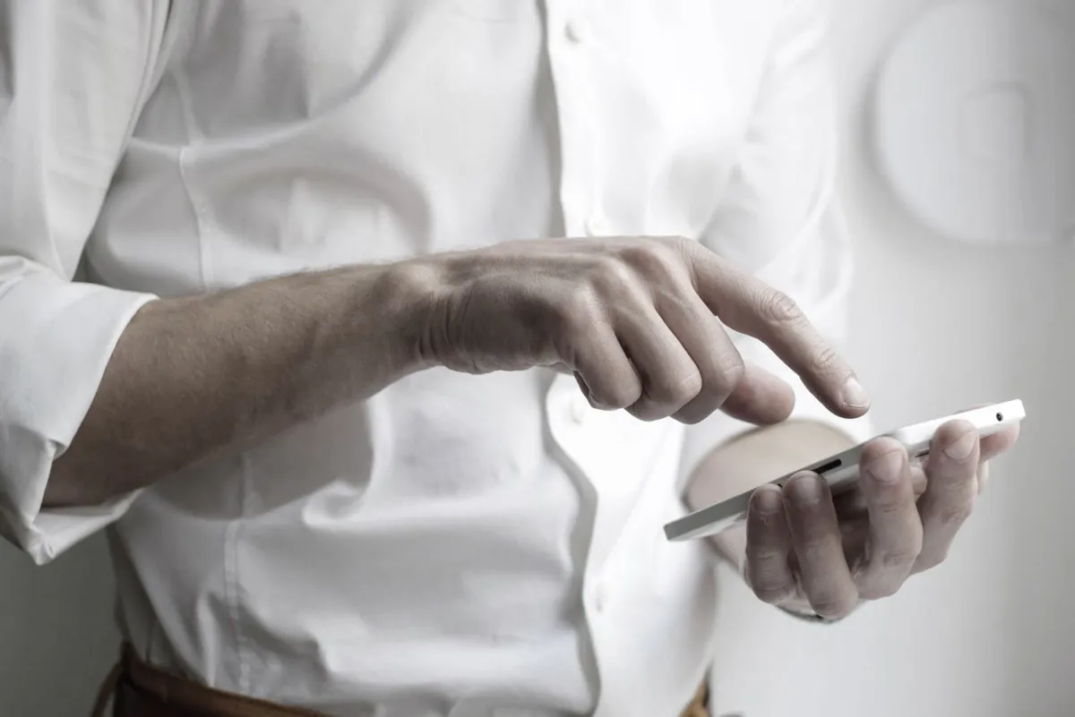 Hand bedient ein Smartphone, Symbol für gute Erreichbarkeit